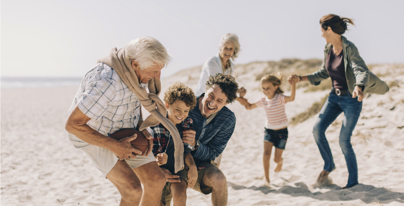 Family on sand playing_1293x659.png